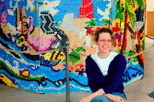 Sarah with the artwork created from bottle caps
